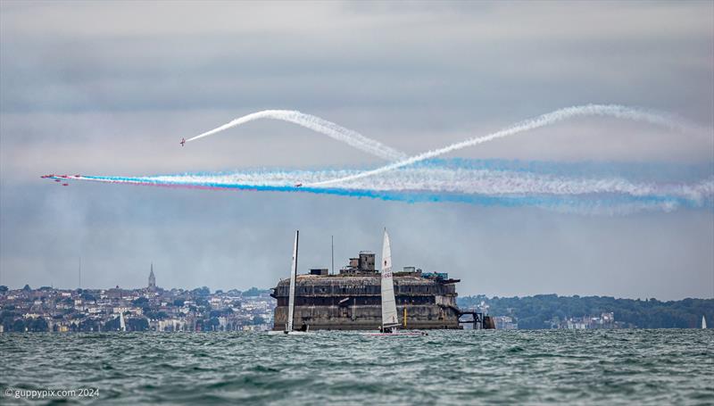 The Red Arrows attempt to distract Hugh Macgregor, on the A-Cat and Andre McQueen on his Unicorn during the Unicorn and A Class Catamaran Nationals at Hayling Ferry SC photo copyright Gordon Upton / www.guppypix.com taken at Hayling Ferry Sailing Club and featuring the A Class Catamaran class