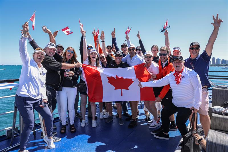 Jubilant supporters of the Canada SailGP Team hold the flag as they watch the action from the Adrenaline Lounge spectator boat on Race Day 1 of the T-Mobile United States Sail Grand Prix | Chicago at Navy Pier, Lake Michigan, Season 3 June 2022 photo copyright Katelyn Mulcahy/SailGP taken at Chicago Yacht Club and featuring the F50 class