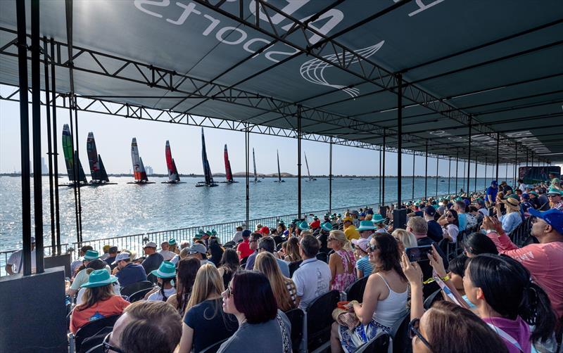 Spectators in the grandstand watch as the SailGP fleet of F50 catamarans pass on Race Day 1 of the Mubadala Abu Dhabi Sail Grand Prix presented by Abu Dhabi Sports Council in Abu Dhabi, United Arab Emirates. 13th January photo copyright Christopher Pike for SailGP taken at  and featuring the F50 class