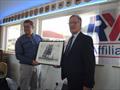 Joint Henri Lloyd CEO, Paul Strzelecki, presents Toddbrook SC Commodore, John Swales with a photo signed by Sir Ben Ainslie's America's Cup team © TSC