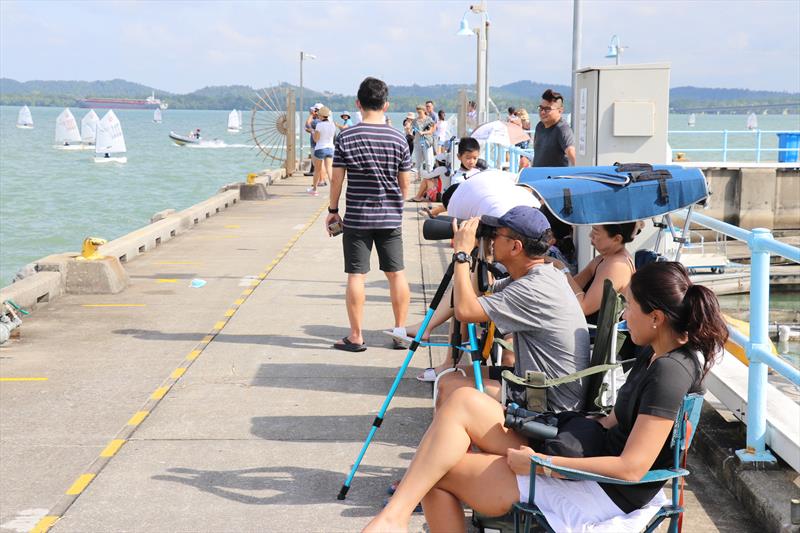 Parents braved the heat along the breakwater to watch their children race - Raffles Marina Optimist Regatta 2022 photo copyright Raffles Marina taken at Singapore Sailing Federation and featuring the Optimist class