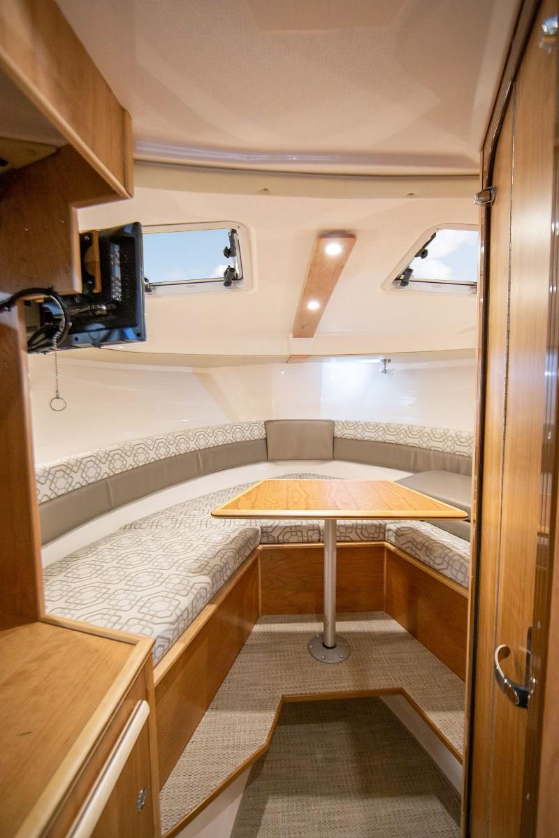 The forward berth features large opening hatches, port lights, a TV/DVD player and a game-table. - photo © Cutwater Boats