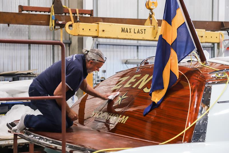 Hand-polishing the mahogany transom, beneath the Swedish flag - photo © J Craft Boats