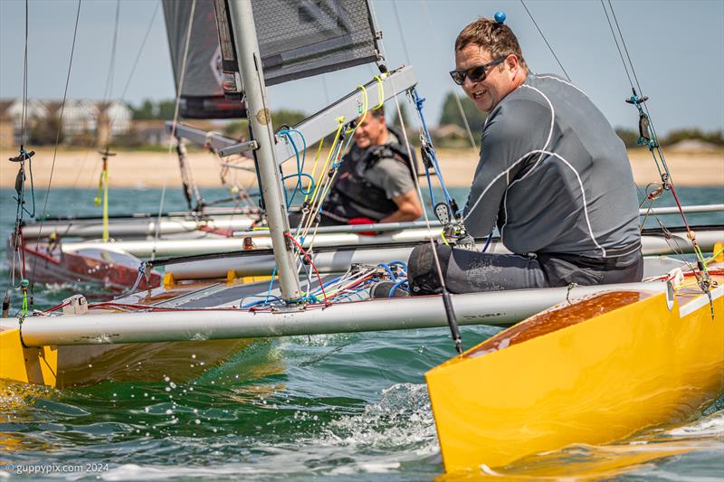 William Dawson can't resist a smile as he narrowly sneaks over the line ahead of Dan Jarman on day 2 of the Unicorn and A Class Catamaran Nationals at Hayling Ferry SC photo copyright Gordon Upton / www.guppypix.com taken at Hayling Ferry Sailing Club and featuring the Unicorn class